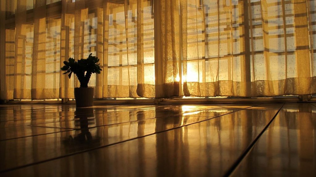 Transparante inbetween gordijnen met grove gaasstructuur in woonkamer, toont lichtinval en privacy overdag
